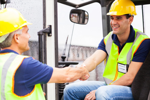 Jefe de almacén saludando al oparario carretillero.